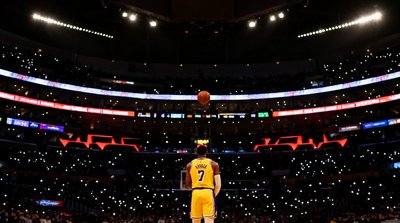 NBA比赛直播画面，湖人主场斯台普斯中心内景，球员正在罚球线准备罚球，观众席灯光璀璨